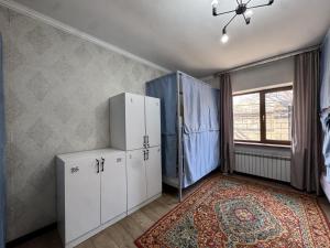 a bedroom with white cabinets and a window at Meridian Hostel in Almaty