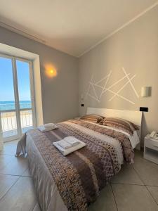 a bedroom with a bed with a view of the ocean at Hotel Gandolfo in Alassio