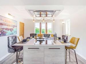 a kitchen with a large white island with chairs at 4 Bed in Skipton oc-89095 in Starbotton