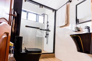 a bathroom with a glass shower with a toilet at The Crest Apartment in Kigali