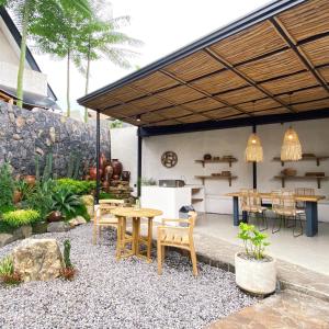 a patio with a table and chairs under awning at Casa Benna - Salatiga in Salatiga