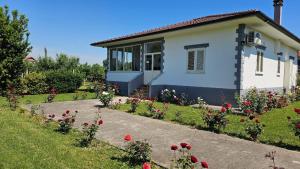 a house with flowers in front of it at Vila Rrozhani in Mabë