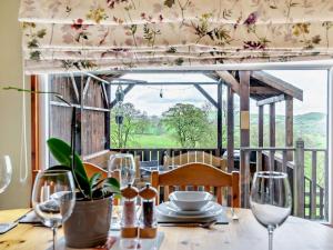 a table with wine glasses and a view of the countryside at 2 Bed in Leek oc-52923 in Grindon