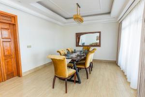 a dining room with a table and yellow chairs at The Crest Apartment in Kigali