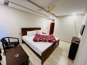 a bedroom with a bed with a red pillow on it at Citymax Hotel in Rawalpindi +58 photos