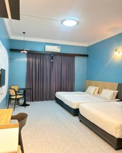 a hotel room with two beds and a table at SURIA BEACH RESORT Pangkor in Pangkor +12 photos