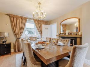 a dining room with a table with chairs and a chandelier at 5 Bed in Pershore oc-91349 in Peopleton