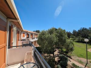 a balcony of a building with a tree at VTF Village de vacances Le Domaine d'Agde in Agde