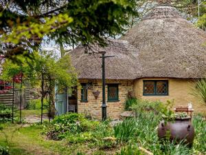 een klein bakstenen huisje met een rieten dak bij 2 Bed in Wareham oc-79305 in East Stoke