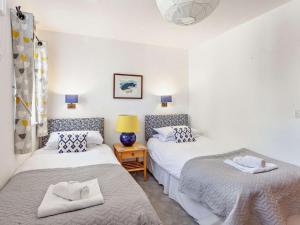 a bedroom with two beds and a night stand with a lamp at 2 Bed in Malmesbury oc-91453 in Malmesbury