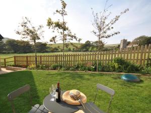 a table with a hat and a bottle of wine at 3 Bed in Wareham oc-dc137 in West Lulworth