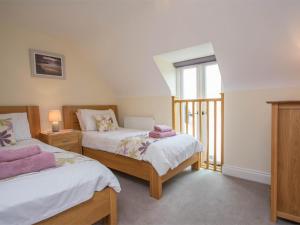 a bedroom with two beds and a window at 3 Bed in Wareham oc-dc137 in West Lulworth