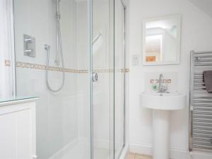 a white bathroom with a shower and a sink at 3 Bed in Wareham oc-dc137 in West Lulworth +10 photos