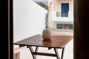 a vase sitting on a wooden table on a balcony at Elysian Studio A4 in Karpathos