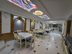 a dining room with tables and chairs and a stained glass window at Al Samarqandi Hotel in Samarkand