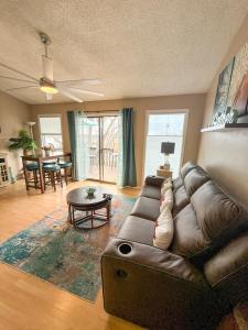 a living room with a leather couch and a table at The Little Penthouse in Lake Ozark