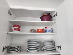 a pantry with plates and bowls on shelves at Villa chez Fred in Le Quesnoy