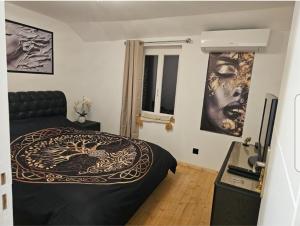 a bedroom with a bed and pictures on the wall at Villa chez Fred in Le Quesnoy