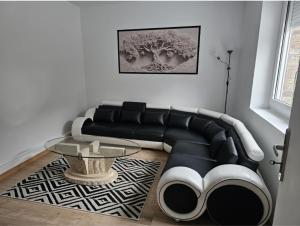 a living room with a black couch and a table at Villa chez Fred in Le Quesnoy