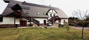 a large white house with a black roof at Farma U Nýdrlů in Stará Červená Voda