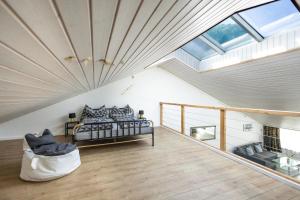 a bedroom with a bed and a couch in a attic at Muota River Loft & Muota Industry Apartment near Stoos in Muotathal