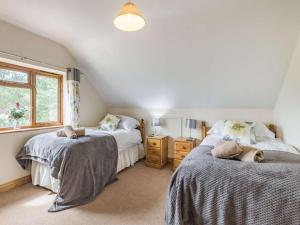 a attic bedroom with two beds and a window at 4 Bed in Worcester oc-77991 in Clifton upon Teme
