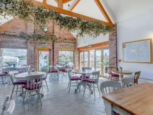 a dining room with tables and chairs and a brick wall at 4 Bed in Worcester oc-77991 in Clifton upon Teme