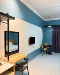 a room with a bed and a table and chairs at SURIA BEACH RESORT Pangkor in Pangkor