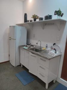 a kitchen with a sink and a refrigerator at Apto Candelária in Rio de Janeiro