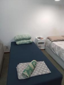 a room with two beds and a table with a pillow at Apto Candelária in Rio de Janeiro +8 photos