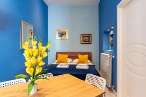 ein blaues Zimmer mit einem Bett und einem Tisch in der Unterkunft Plebiscito 10 in Neapel