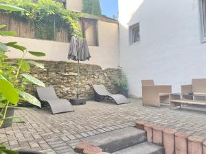 a patio with two chairs and an umbrella at Ferienwohnung Kleinôd Sayn in Bendorf