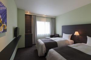 Ένα ή περισσότερα κρεβάτια σε δωμάτιο στο Ginza Grand Hotel