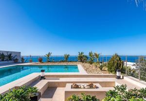 a swimming pool with the ocean in the background at Borderline in Al Matlīn