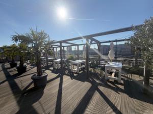 a deck with tables and palm trees on a building at Printhouse in Münster
