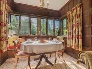 a dining room with a table and chairs and windows at 1 Bed in Penrith oc-sz350 in Orton