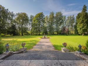 a path through a park with a person sitting on a bench at 1 Bed in Penrith oc-sz350 in Orton +7 photos