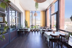 a restaurant with tables and chairs and large windows at L'Aptois Hôtel - Centre Ville - Local Vélos in Apt
