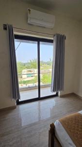a bedroom with a large window with a view at Noble Grand Villa in Mahabalipuram