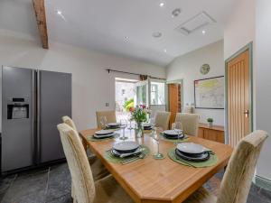 a kitchen and dining room with a wooden table and chairs at 3 Bed in Hexham oc-96038 in Bardon Mill
