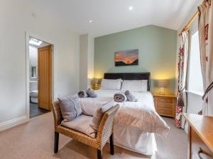 a bedroom with a large bed and a chair at 3 Bed in Hexham oc-96038 in Bardon Mill