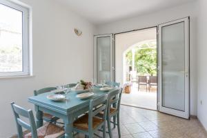 a dining room with a blue table and chairs at Villa Florence - Mediterranean GardenPool in Zaton