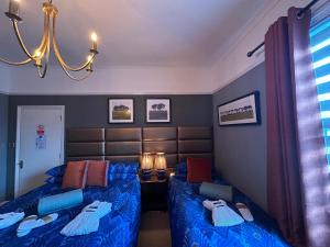 a bedroom with two beds and a table with lamps at Worth House in Cambridge