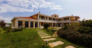 a large yellow house with a lawn in front of it at Complex Villas Kaliakra & Gradina in Bŭlgarevo
