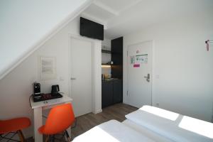 a room with a bed and a desk and a kitchen at Printhouse in Münster