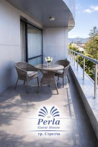 a patio with a table and chairs on a balcony at Хотел PERLA in Strelcha +23 photos