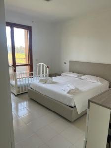 a bedroom with a large bed and a baby crib at Dimora Maffi in Metaponto