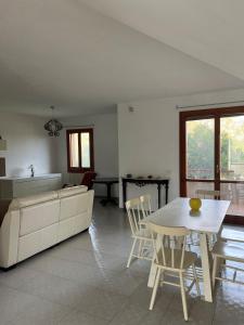 a living room with a couch and a table and chairs at Dimora Maffi in Metaponto