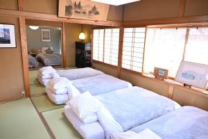 a room with two beds and chairs in it at Zen House - Tajimi in Tajimi