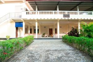 a large white building with a walkway in front of it at G K Guest House in Kalkudah